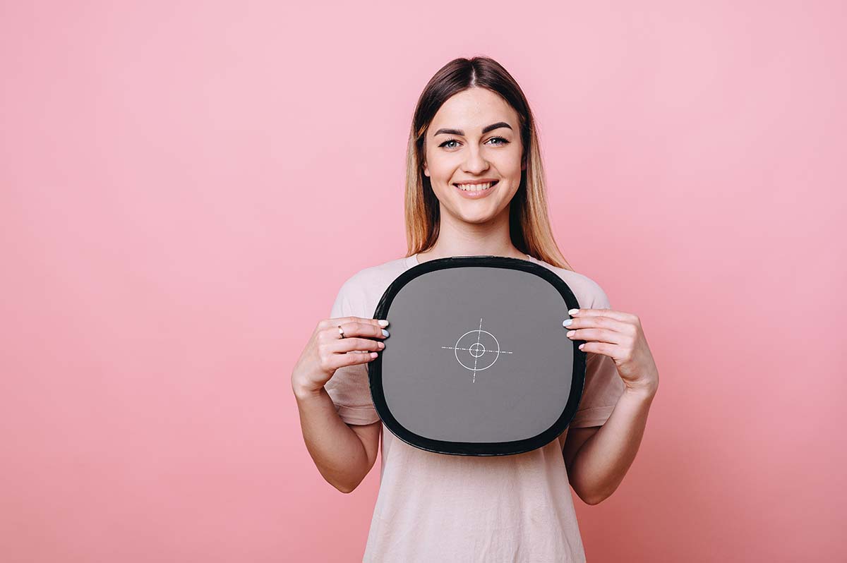 Model Holding Grey Card for White Balance In Studio