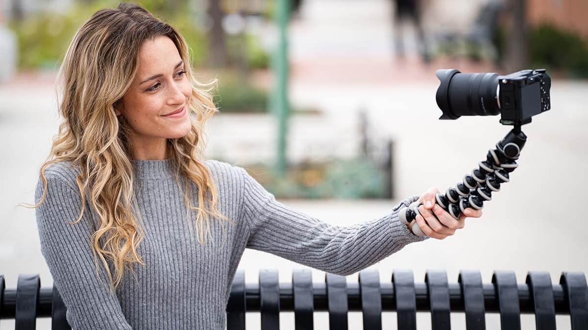 Young Woman Vlogger with Mirrorlesss Camera on Tripod